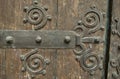 Large grungy wooden gate with metal forged design elements. Weathered wood, historical place in Spain, Europe