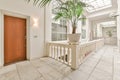 a large hallway with a wooden door and a plant