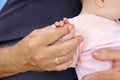 The Large Hand of a Man Holding the Tiny Fingers of a Baby Girl Royalty Free Stock Photo