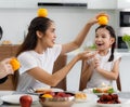 A large, happy Asian family spends time dining at a table in their home. Little daughters chat and play games freely. Som has fun Royalty Free Stock Photo