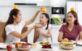 A large, happy Asian family spends time dining at a table in their home. Little daughters chat and play games freely. Som has fun Royalty Free Stock Photo