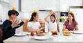 A large, happy Asian family spends time dining at a table in their home. The little daughters chatted and played games for free Royalty Free Stock Photo