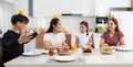 A large, happy Asian family spends time dining at a table in their home. The little daughters chatted and played games for free Royalty Free Stock Photo