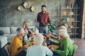 Large happy family gather party celebrate thanksgiving day sit table enjoy roast chicken meal man stand hold champagne Royalty Free Stock Photo