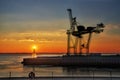 Large harbor crane in front of colorful sunset