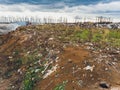 The large heap garbage dump extends parallel to the river,Garbage mountains with cloudy sky back ground in day light Royalty Free Stock Photo