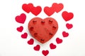 A large heart made of paper hearts laid out on a white background in the middle of a cardboard heart and glass hearts Royalty Free Stock Photo