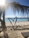 Large heart on the beach made of palm leaves