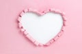 Large heart-shaped hole in pink paper