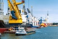 Large heavy-duty container ship with smaller boats in the port o