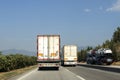 Large and heavy vehicles traveling side by side on the highway. traffic generated trucks. Royalty Free Stock Photo