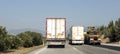 Large and heavy vehicles traveling side by side on the highway. traffic generated trucks. Royalty Free Stock Photo