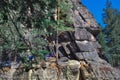 Large high rough climbing rock Vityaz in Siberian forest with conifers in winter in the light of sun. People climbers on big cliff