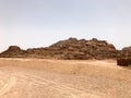 A large high stone sandy mountain in the desert with sand background