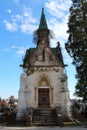 Large highly decorated carved stone family tomb with strong wooden doors locked with metal padlock surrounded with rusted metal