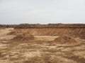 A large hills and pits of sand and traces of a heavy bulldozer and tractors on a autumn forest construction site. Panoramic