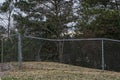 A Large hole cut in to a chain link fence and nature Royalty Free Stock Photo