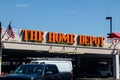 Large Home Depot sign with blue sky a cars