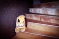 On a wooden staircase leading to the second floor of a residential building, there is a soft toy for small children Royalty Free Stock Photo