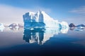 large iceberg reflected on a mirror-like water surface