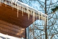 Large icicles hang from a house roof. Dangerous large icicles Royalty Free Stock Photo