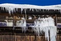 Large icicles hang from a house roof. Dangerous large icicles