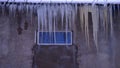 large icicles hang from the roof of the old building