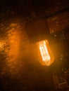 Large incandescent lamp in a dark brick room
