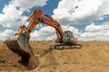 A large industrial excavator work on the construction site.  Cloudy sky Royalty Free Stock Photo