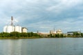 Large industrial factory and silo building at side coast of sea in evening with cloudy sky