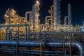 Large industrial gas and oil plant with many pipes and tanks glows