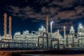 Large industrial gas and oil plant with many pipes and tanks glows