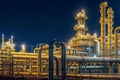 Large industrial gas and oil plant with many pipes and tanks glows