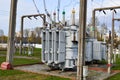 Large industrial iron metal transformer substation with transformers and high-voltage electrical equipment and wires with surge Royalty Free Stock Photo