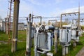 Large industrial iron metal transformer substation with transformers and high-voltage electrical equipment and wires with surge Royalty Free Stock Photo