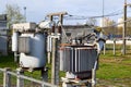 Large industrial iron metal transformer substation with transformers and high-voltage electrical equipment and wires with surge Royalty Free Stock Photo