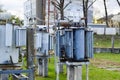 Large industrial iron metal transformer substation with transformers and high-voltage electrical equipment and wires with surge Royalty Free Stock Photo