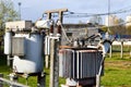 Large industrial iron metal transformer substation with transformers and high-voltage electrical equipment and wires with surge Royalty Free Stock Photo