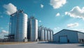 Large industrial storage silos, warehouse under blue sky with clouds. This facility is used for bulk material storage, Royalty Free Stock Photo