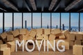 Large industrial urban warehouse with large pile of cardboard moving boxes in front of Skyline, moving 3D Illustration