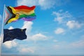 large Inter Progress Pride flag and flag of Alaska state, USA waving at sky. Freedom and love, activism, community concept. Pride