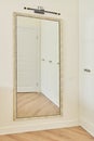 Large interior mirror in vintage white bronze wooden frame on wall