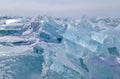 Large iridescent crystal blue white ice floes with cracks shine in the light sun, Baikal, endless horizon back