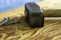 a large iron hammer and nails on a wooden surface Royalty Free Stock Photo