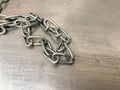 A large iron metal strong powerful shiny chain with links lies on an iron industrial table. Hand-held locksmith tools. The