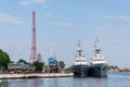 Large iron navy ships in shipyard for repair. Big crane in dockyard. Blue sea harbor. Ships anchorage