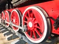 Large iron wheels of a red and black train standing on rails and suspension elements with springs of an old industrial steam Royalty Free Stock Photo