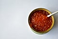 The large jar of red caviar with the spoon
