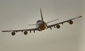 Large jetliner flying through a gray sky with it's landing gear down