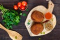 Large juicy cutlets stuffed with boiled egg on a cutting board on a dark wooden background. Scotch egg.